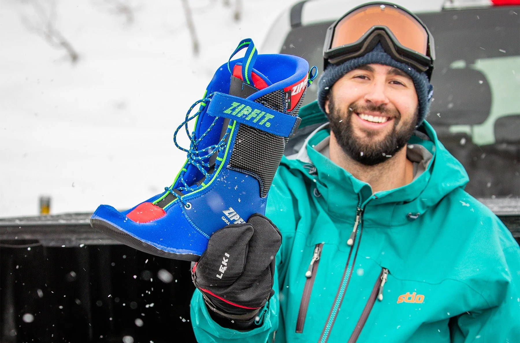 jh-zipfit-alta-75i2478-1-of-1_42e363a5-48fe-4db3-9860-0d62e331bb85 Lächelnder Skifahrer mit ZipFit-Skischuh in der Hand