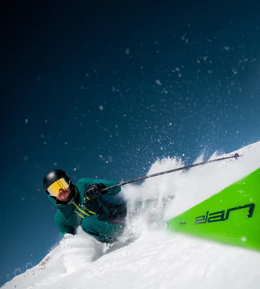 Skifahrer carvt bei Sonnenschein über die Piste